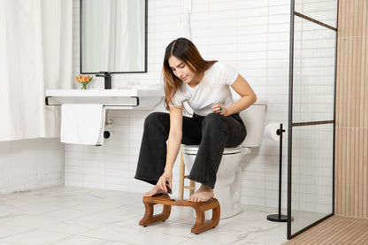 woman dropping essential oils into wood diffuser